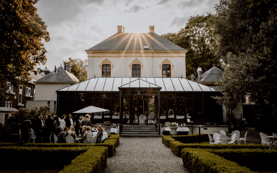een grote groep mensen die buiten voor een gebouw zitten