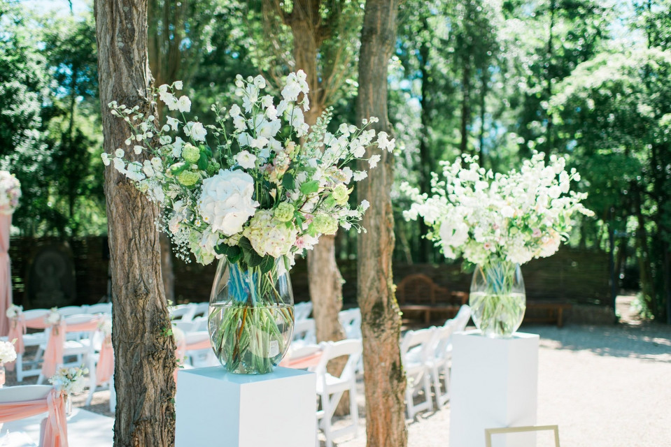 een bruiloftsceremonie met witte vazen en bloemen