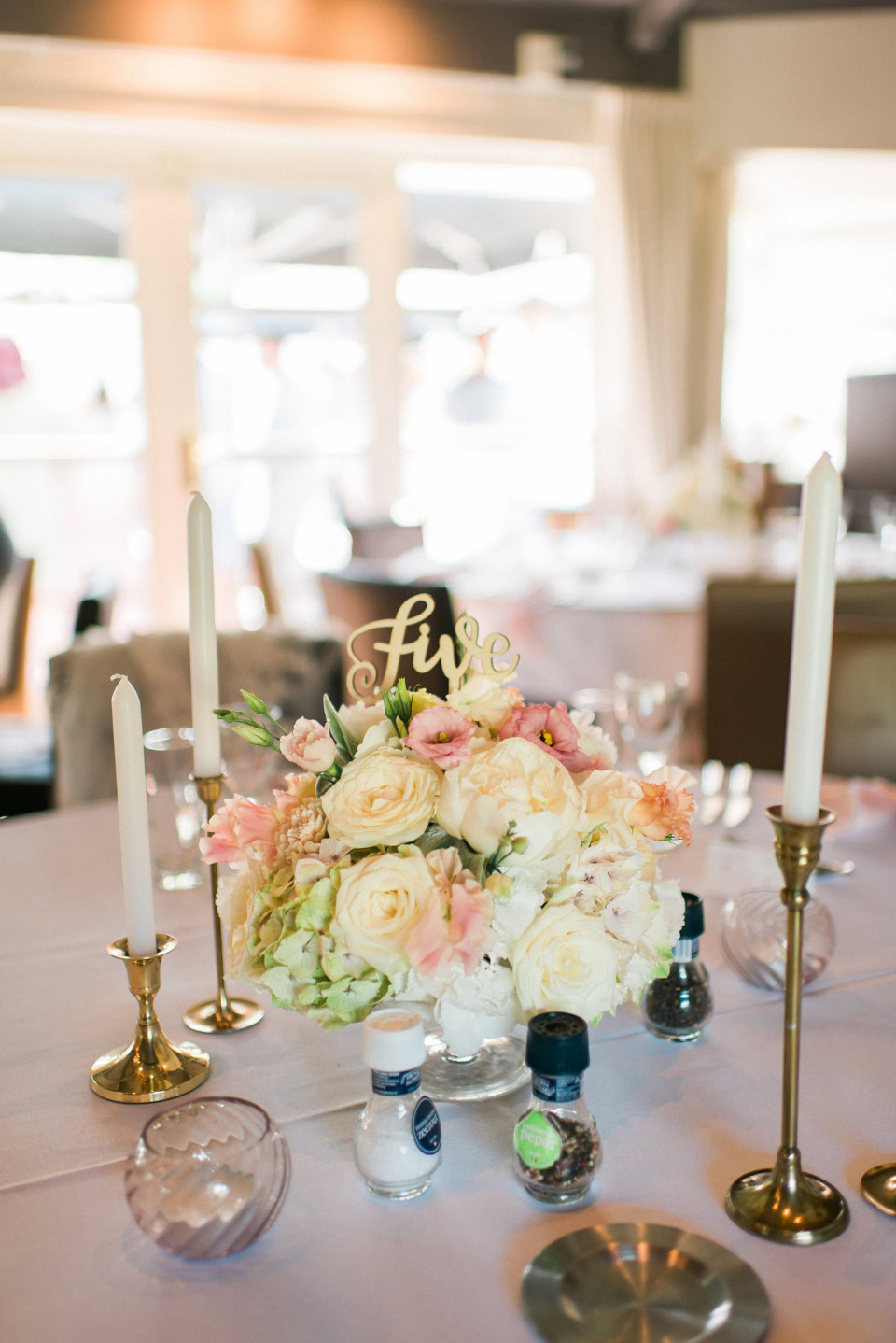 een tafel met kaarsen en bloemen erop