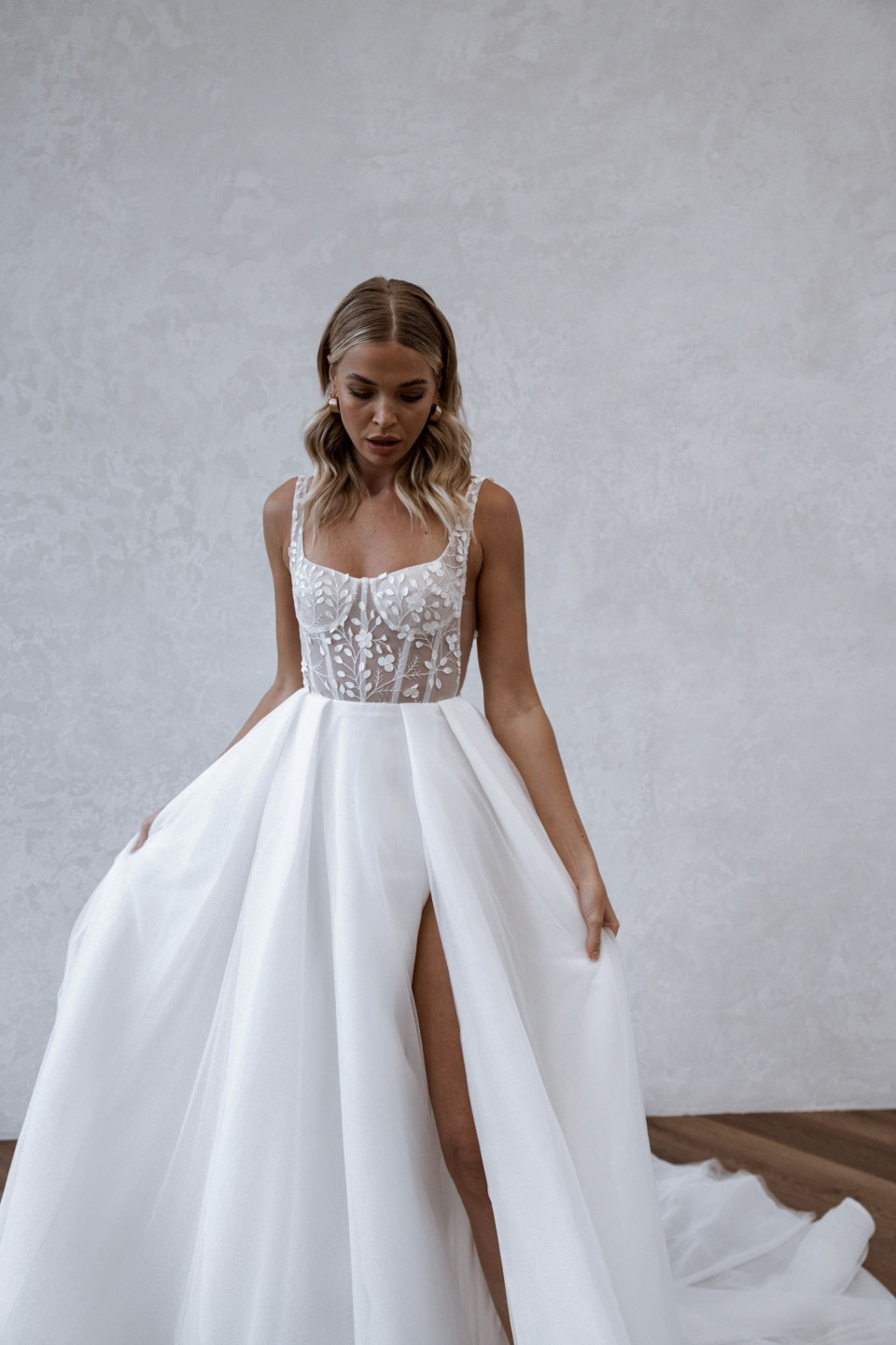 de bruid draagt een witte trouwjurk met een split