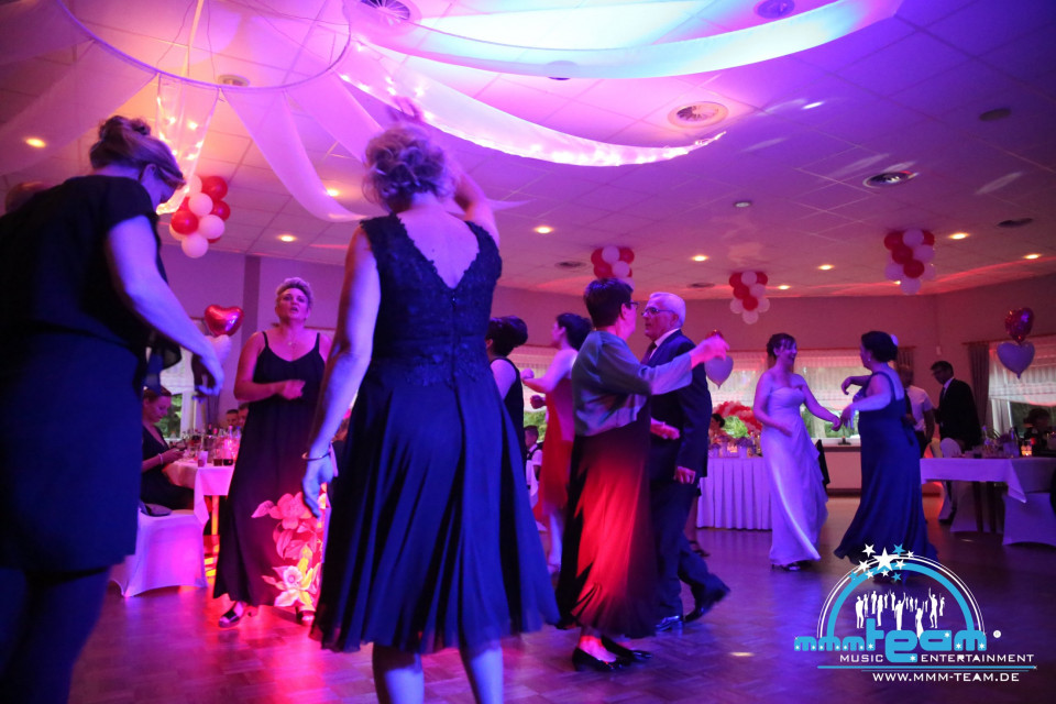 een groep mensen die dansen op een bruiloftsreceptie