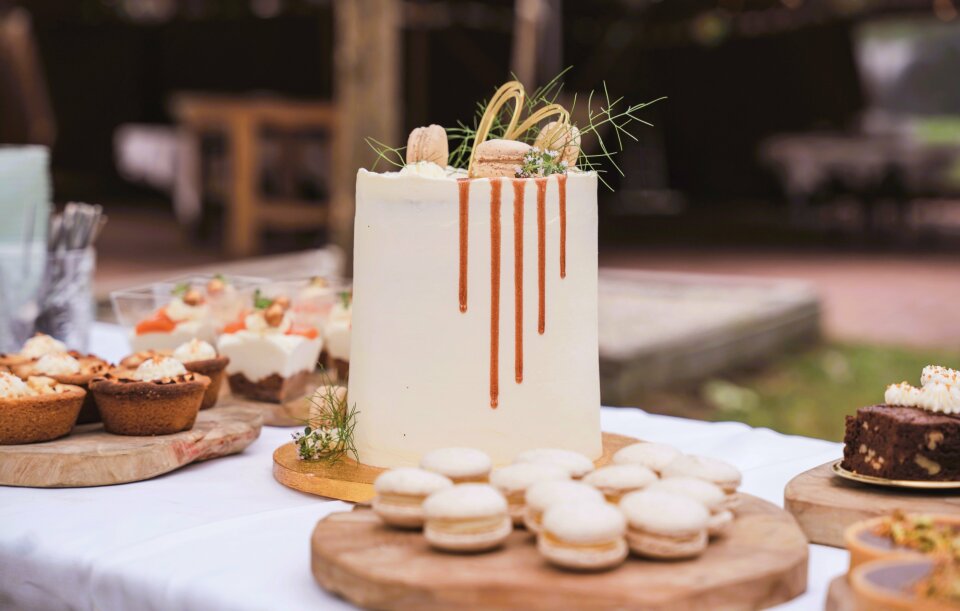 een tafel met een taart en desserts erop