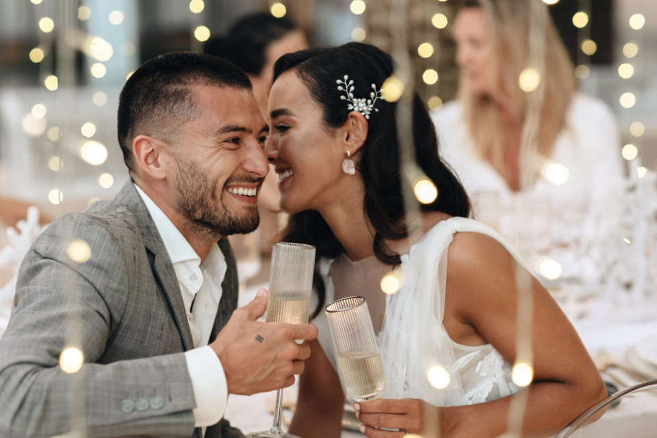 een man en vrouw die een toost delen op een bruiloftsreceptie