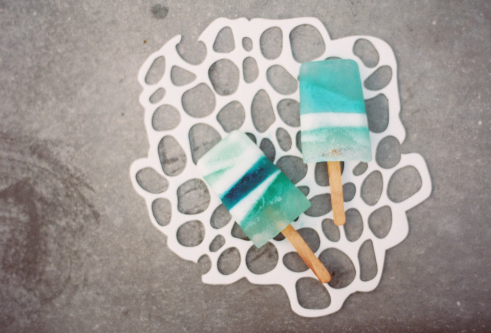 twee ijslolly's op een witte achtergrond met blauwe en groene strepen