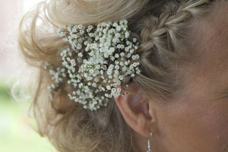 een vrouw met een vlecht in haar haar met een bloem in haar haar