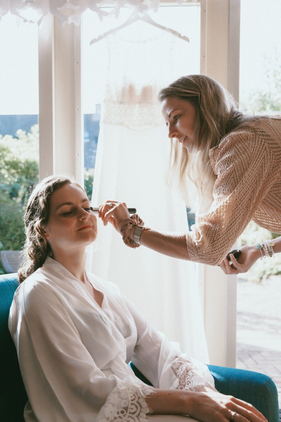 een vrouw die haar make-up laat doen door een andere vrouw