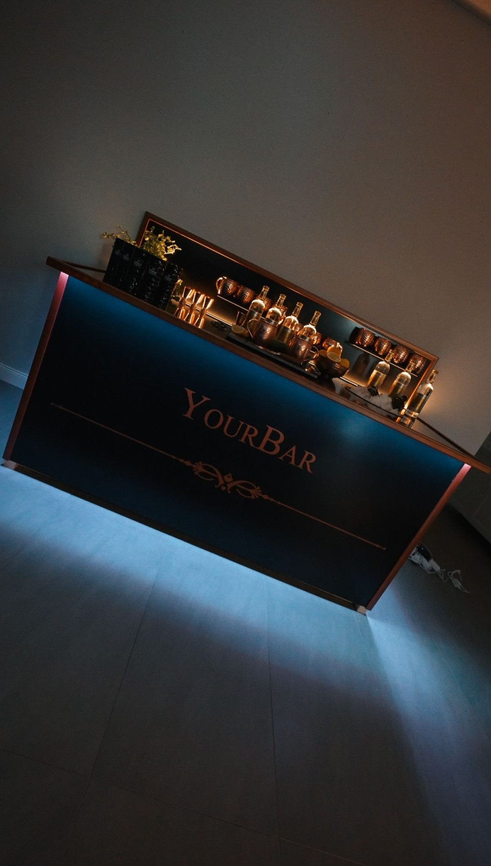een bar met verlichting erop in een donkere kamer