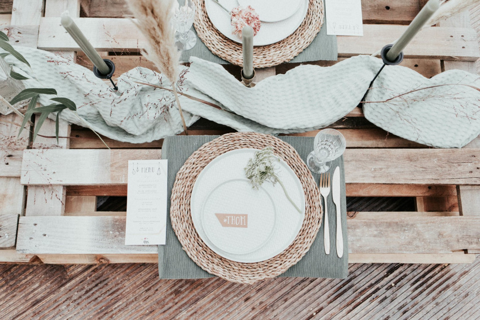 een tafel gedekt met een tafelschikking op een houten pallet