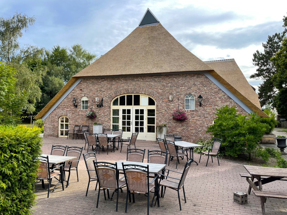 een bakstenen gebouw met tafels en stoelen buiten