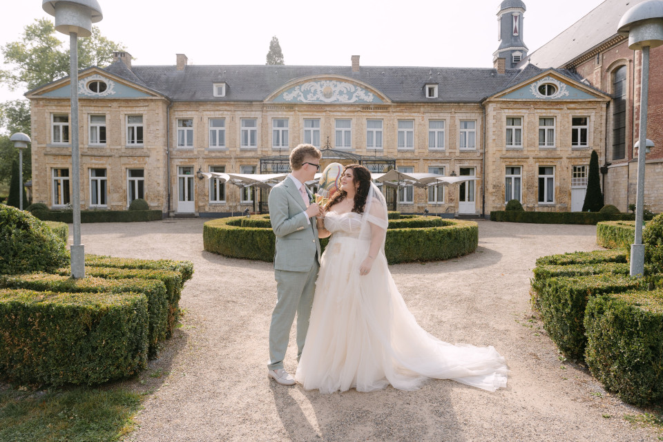 een bruid en bruidegom die voor een groot gebouw staan