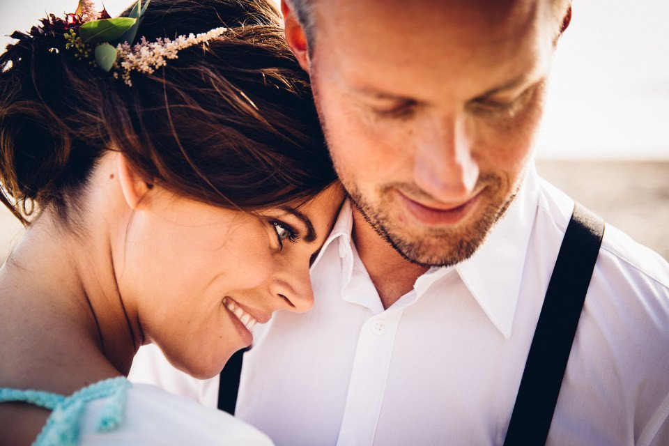 een man en vrouw knuffelen op het strand