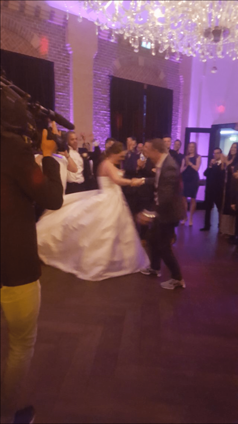 een bruidspaar danst voor een menigte