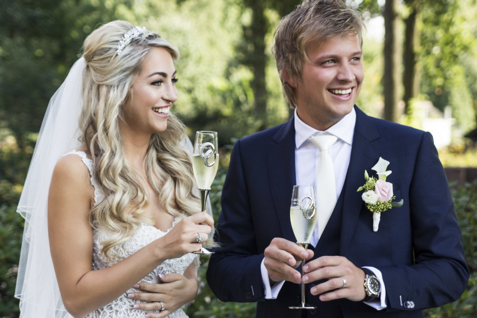 een bruid en bruidegom proosten met champagne