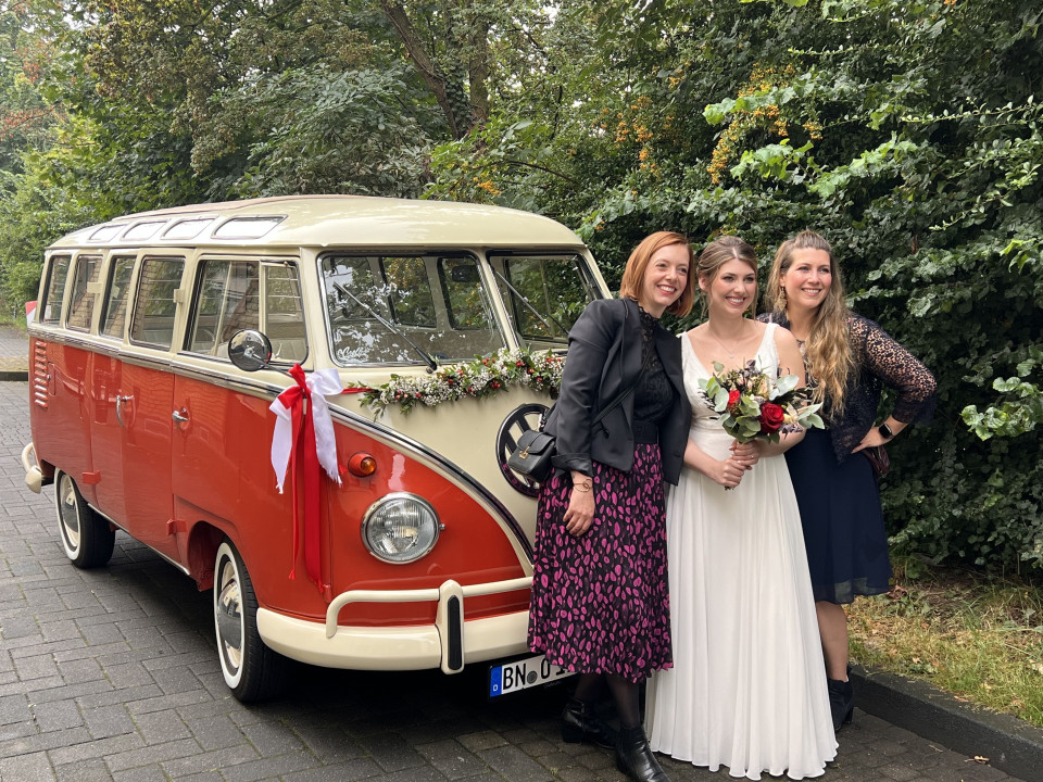 drie vrouwen naast een VW-bus
