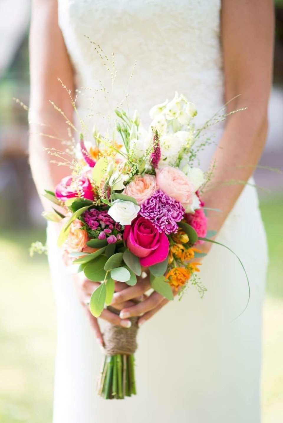 een bruid die een kleurrijk boeket in haar handen houdt