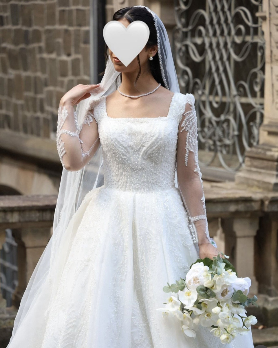 een vrouw in een trouwjurk met een hart op haar hoofd