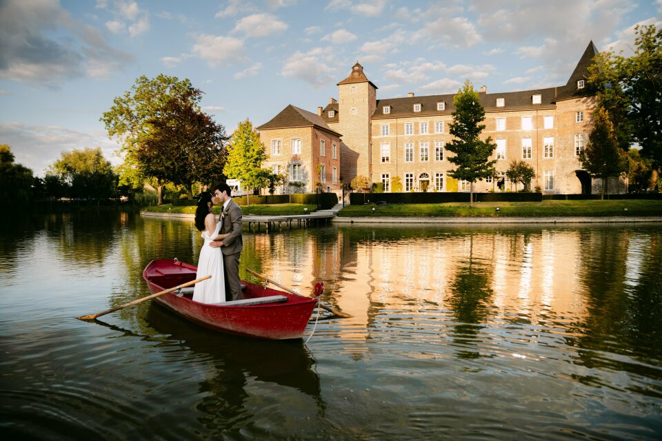 een bruid en bruidegom in een roeiboot op een meer