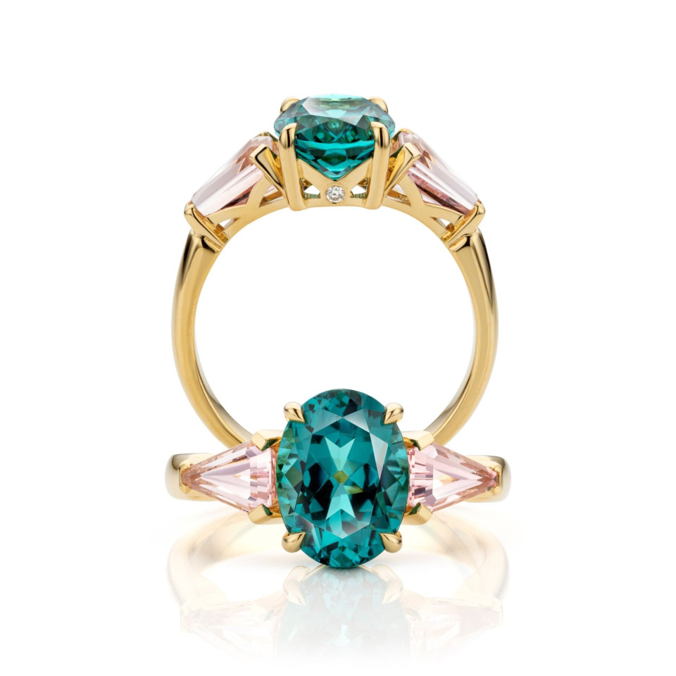 een ring met een ovale groene diamant en roze diamanten