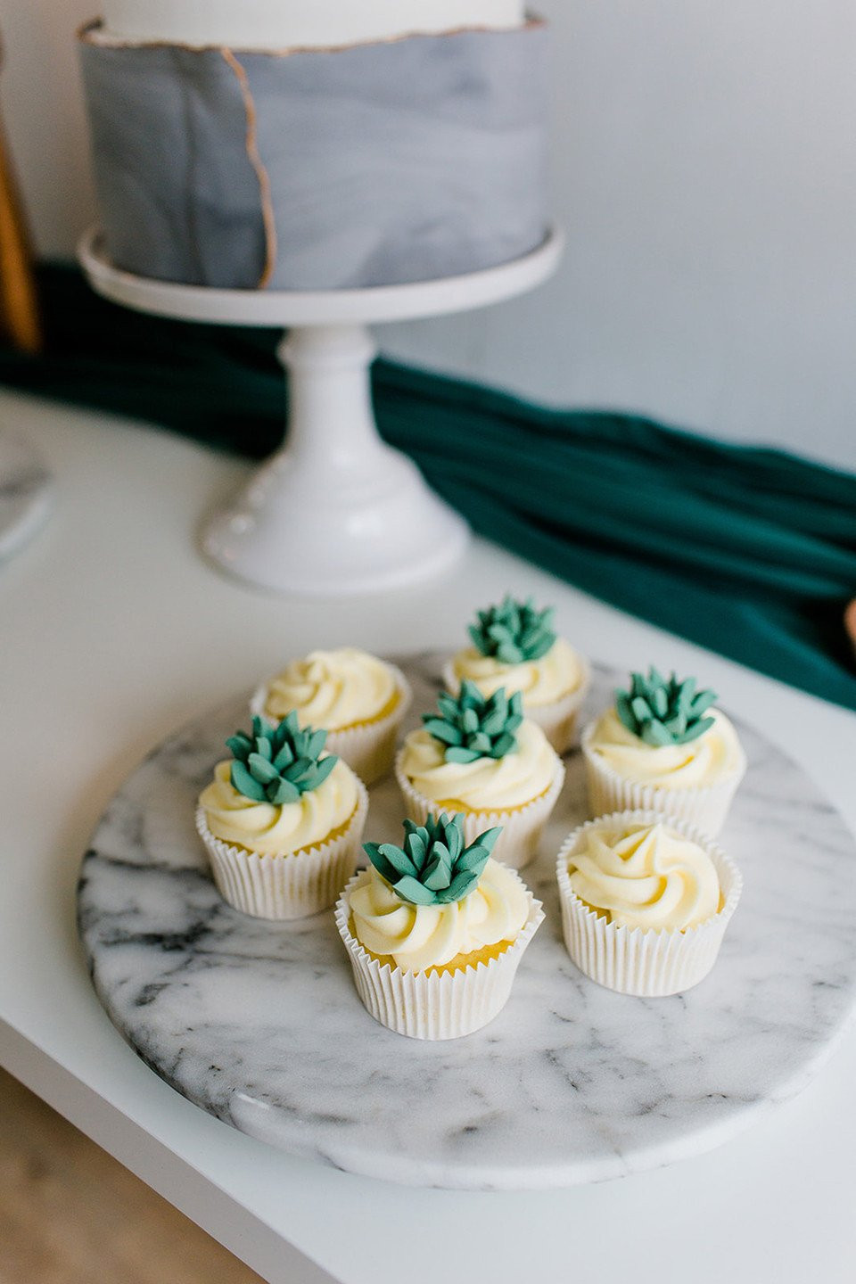 cupcakes op een marmeren schaal met groene bladeren