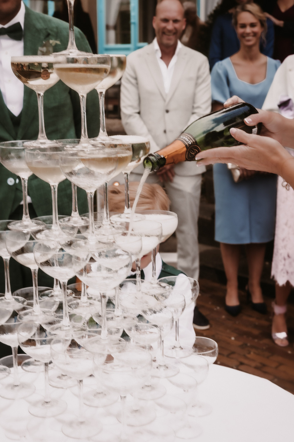 een bruiloftsgroep schenkt champagne in glazen