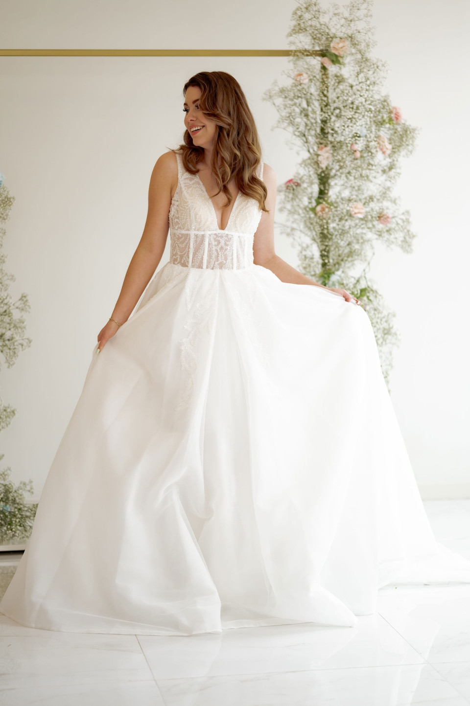 een vrouw in een trouwjurk poseert voor een foto