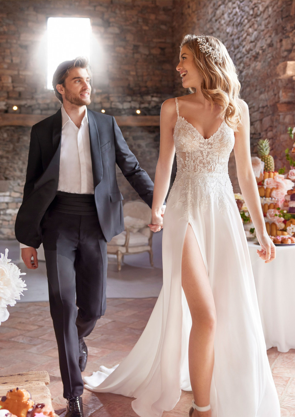 een bruid en bruidegom lopen door een kamer met bloemen
