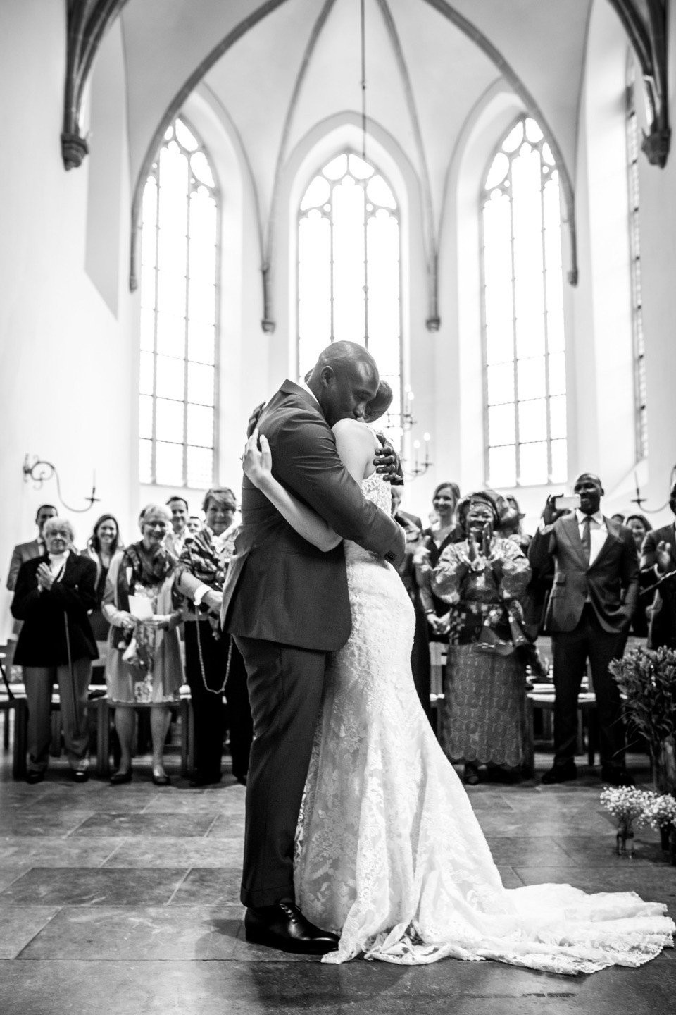 een bruid en bruidegom omhelzen elkaar voor een kerk