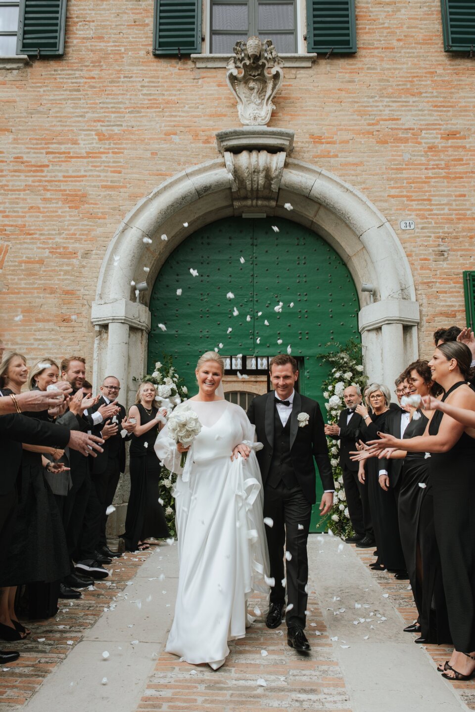 een bruid en bruidegom die met confetti door het gangpad lopen