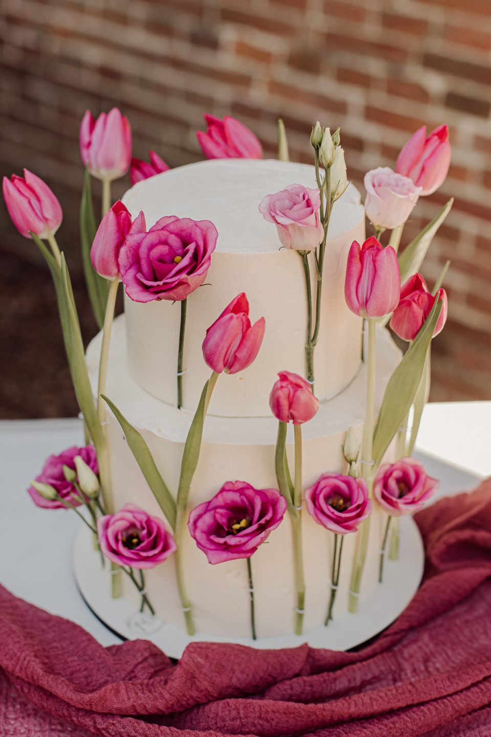 een close-up van een drie-laags taart met roze bloemen