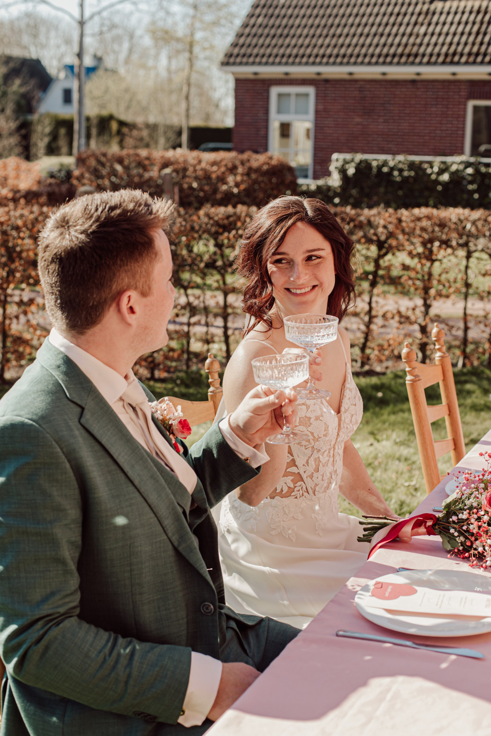 een man en een vrouw die aan een tafel zitten en wijn drinken