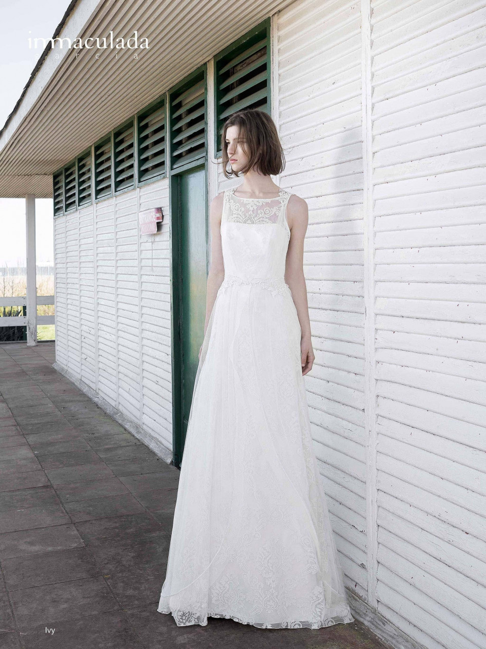 een vrouw in een trouwjurk die buiten bij een gebouw staat