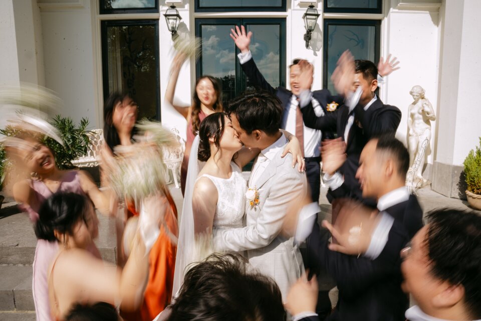 de bruid en bruidegom die in het midden van het trouwfeest kussen