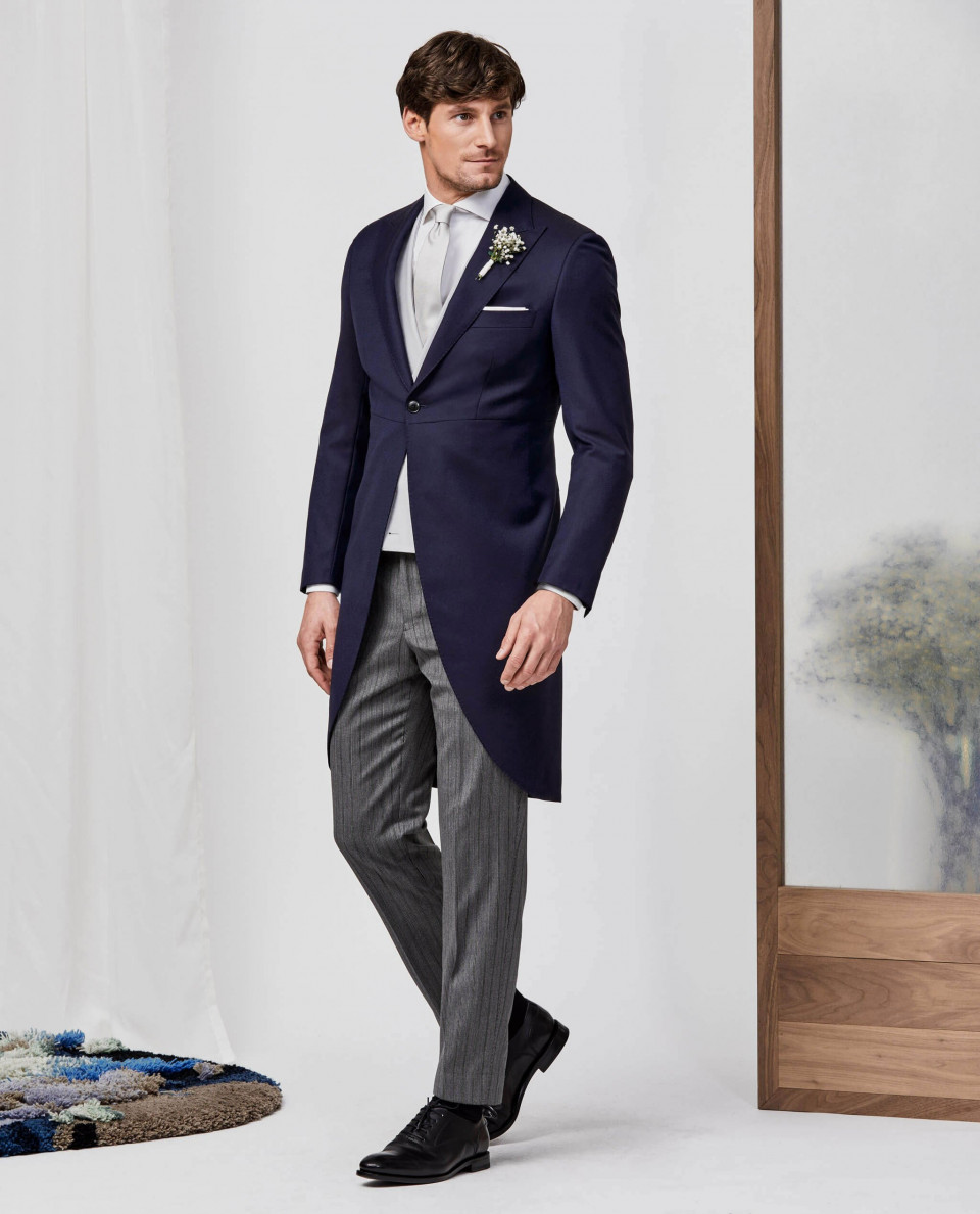 een man in een pak en stropdas die voor een spiegel staat