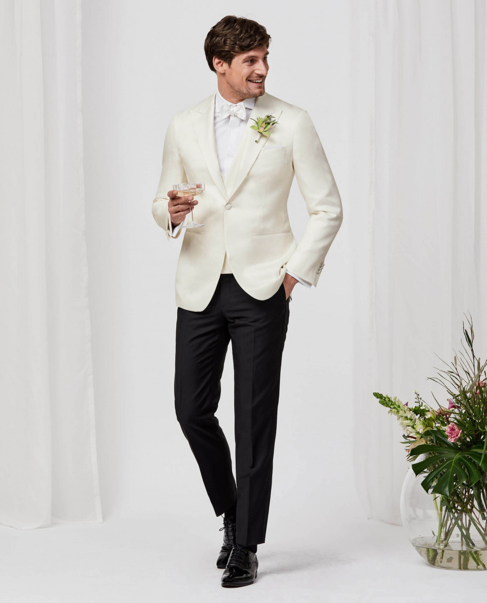 een man in een wit smoking en zwarte broek