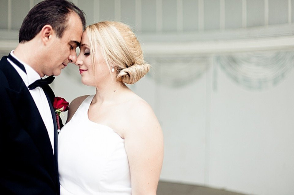 een bruid en bruidegom staan samen in een witte kamer