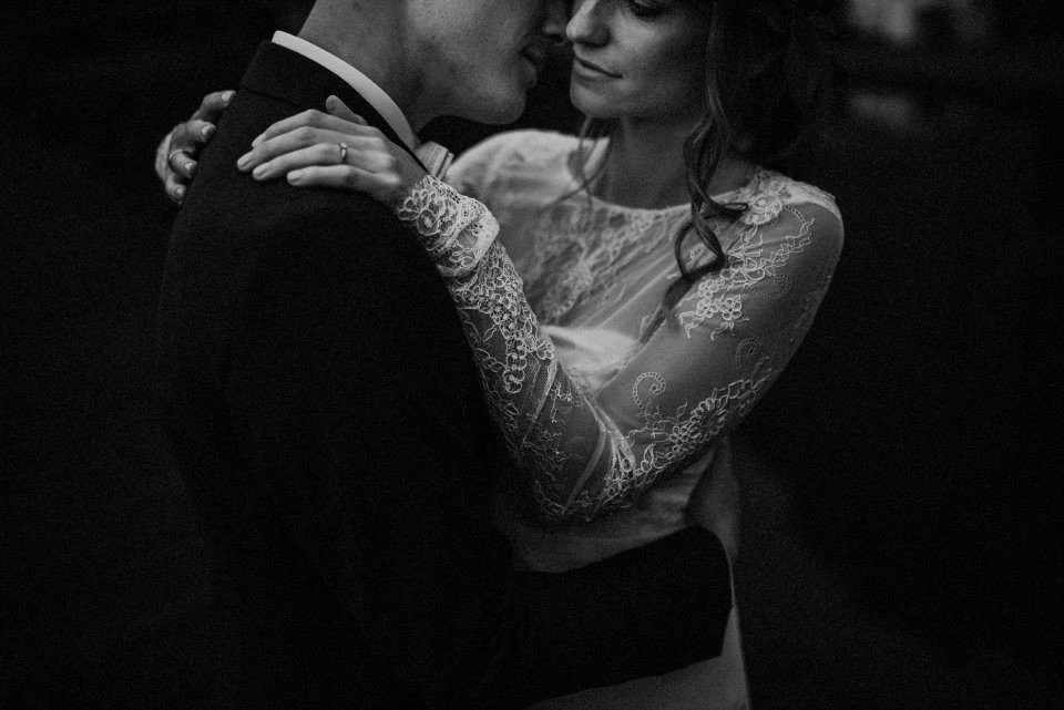 een bruid en bruidegom omhelzen in zwart-wit