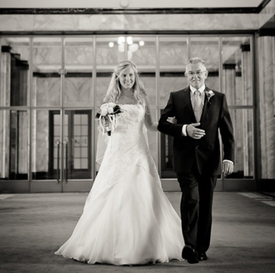 een bruid en haar vader lopen door het gangpad