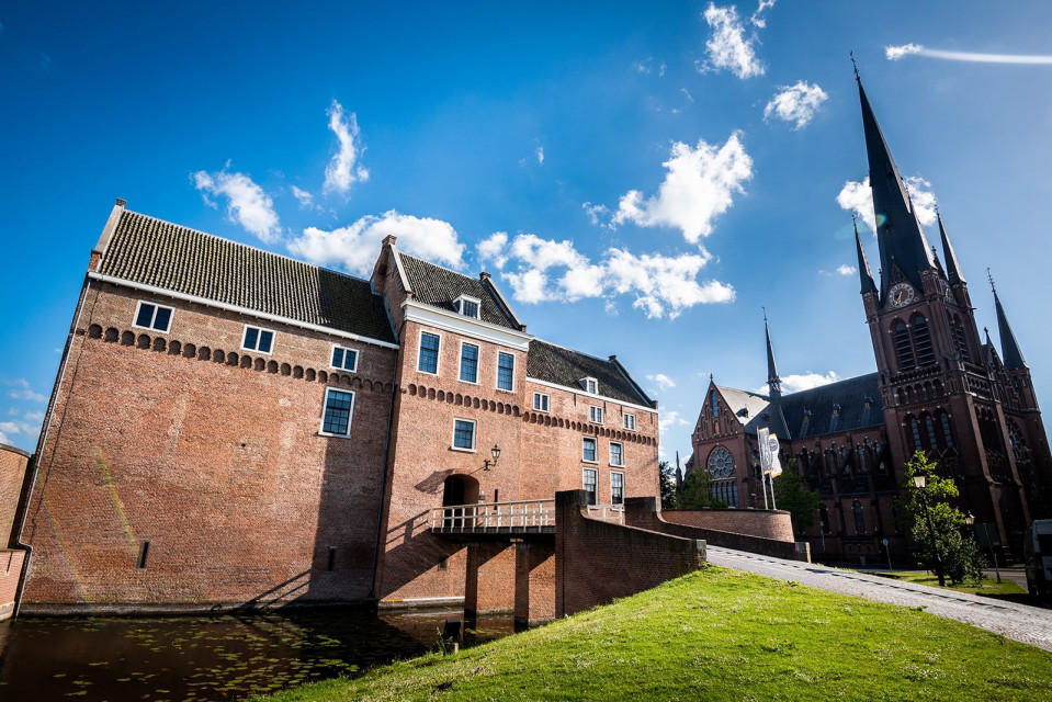 een groot bakstenen gebouw met een klokkentoren en een kerk