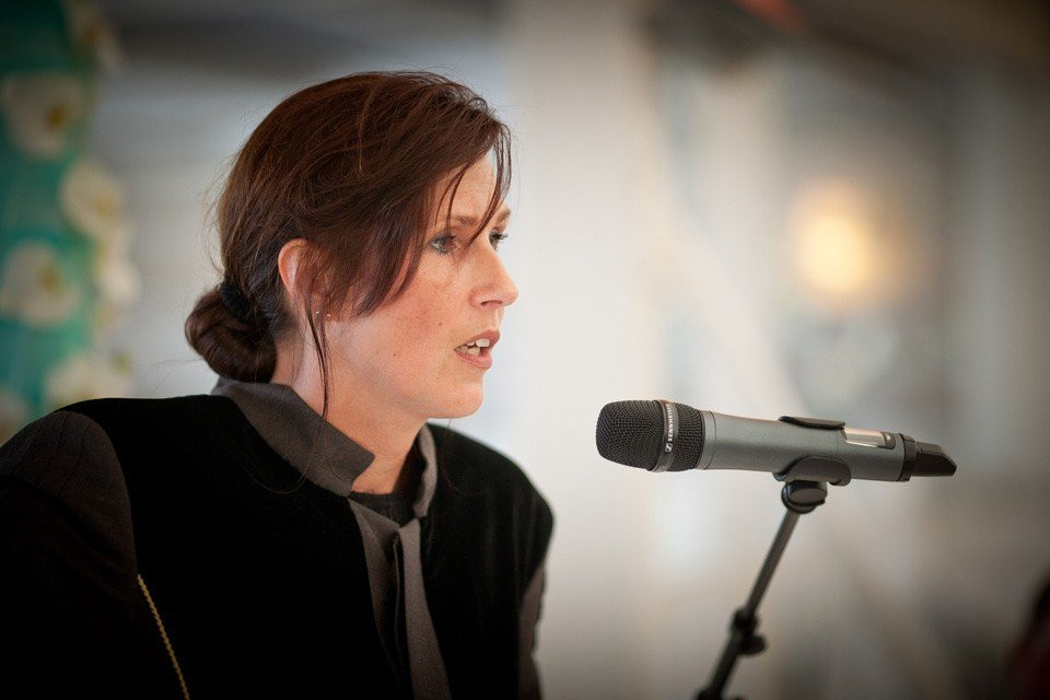 een vrouw die in een microfoon spreekt