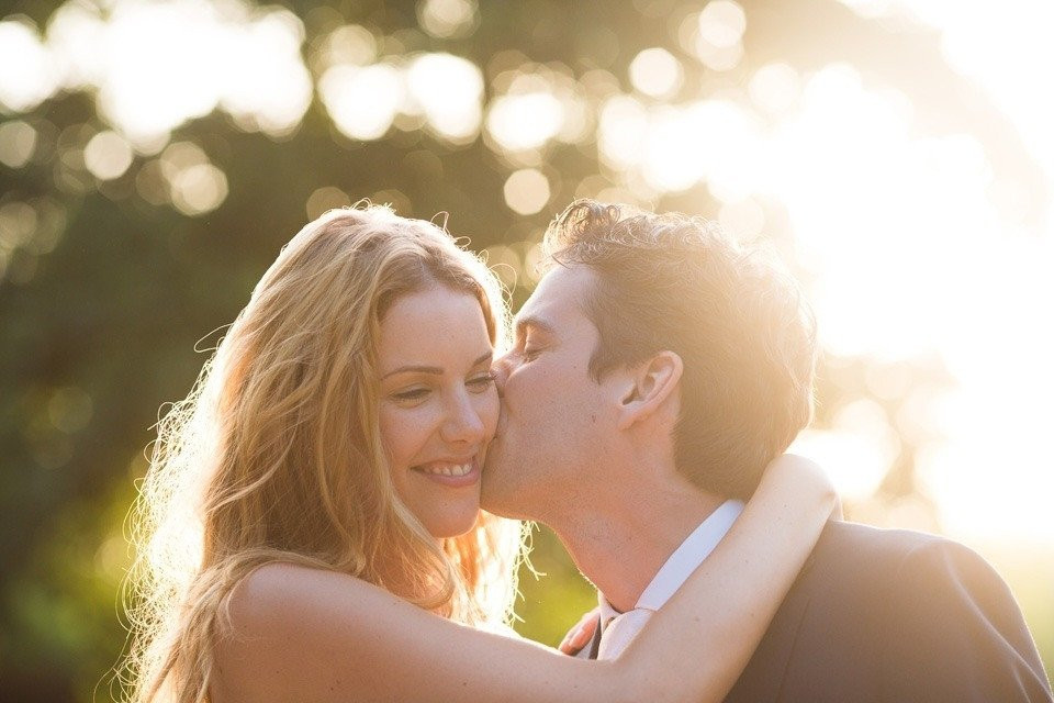 een man en vrouw die kussen in de zon