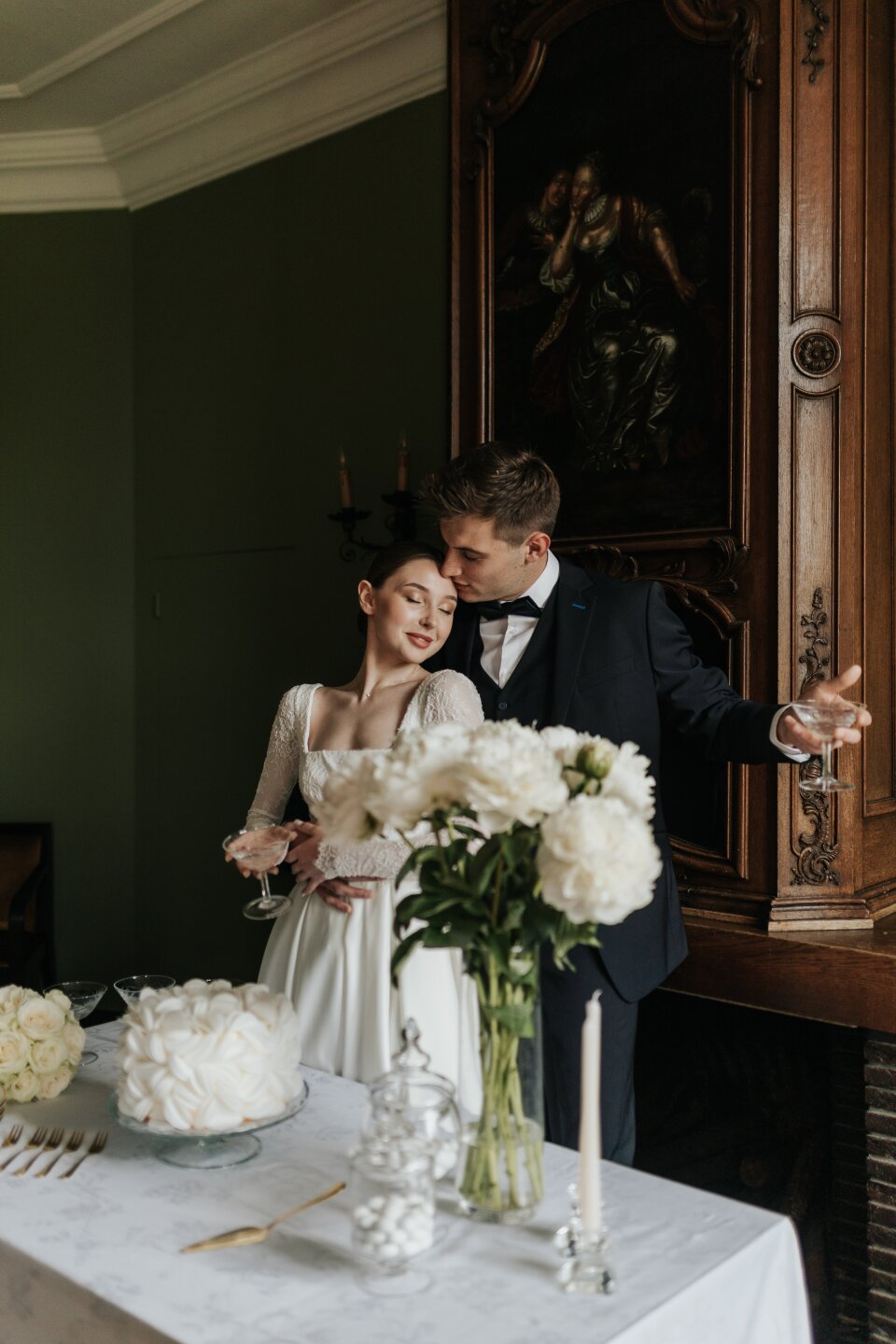 een man en een vrouw die naast een tafel met een taart staan
