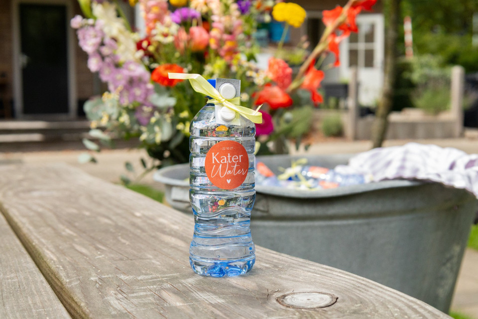 een fles water die op een picknicktafel staat