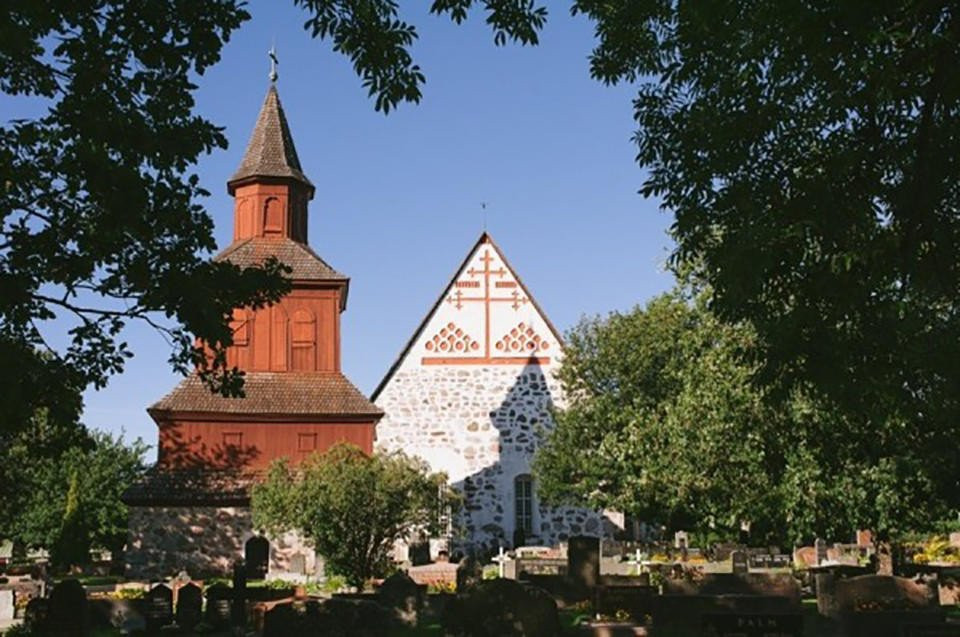 een kerk met een kerktoren en een kerkhof