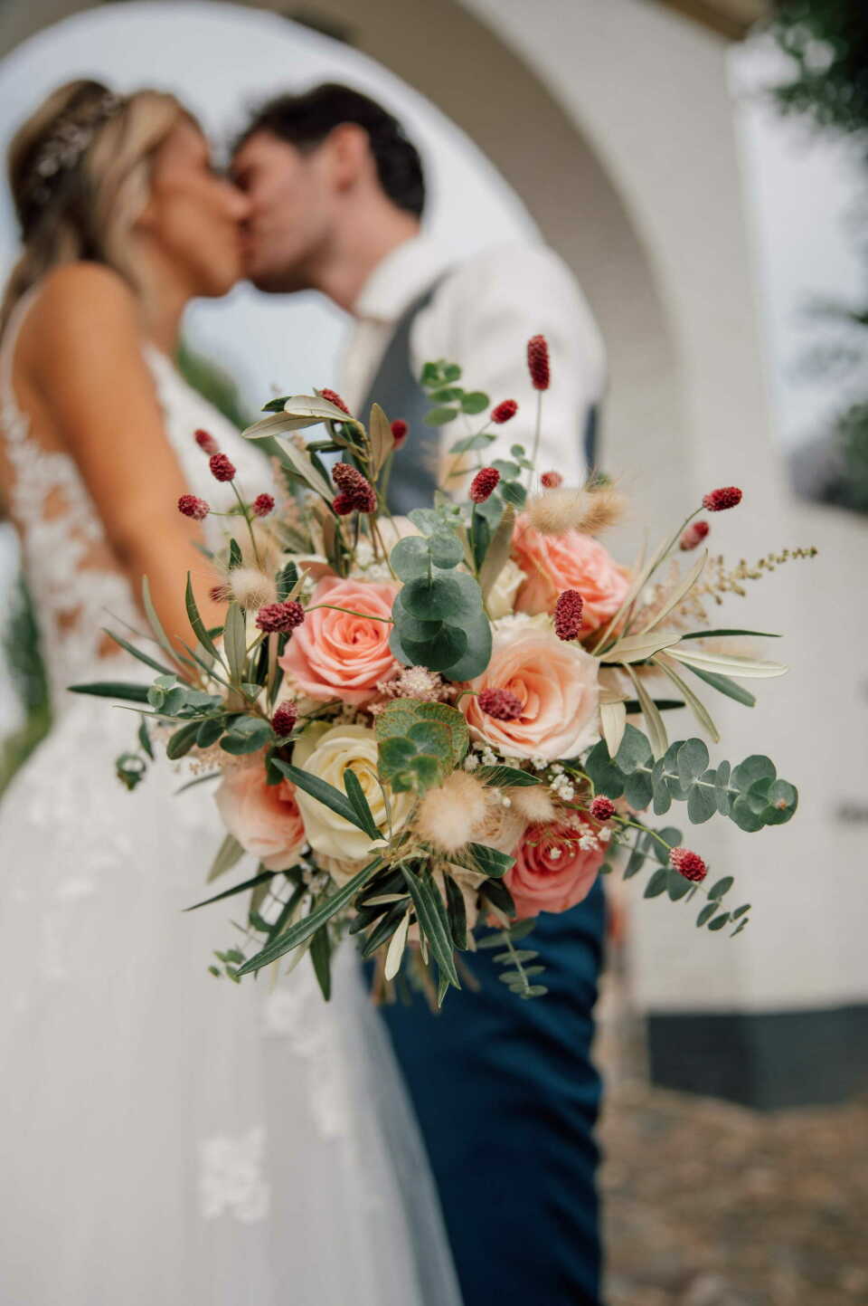 de bruid en bruidegom die kussen voor de boog