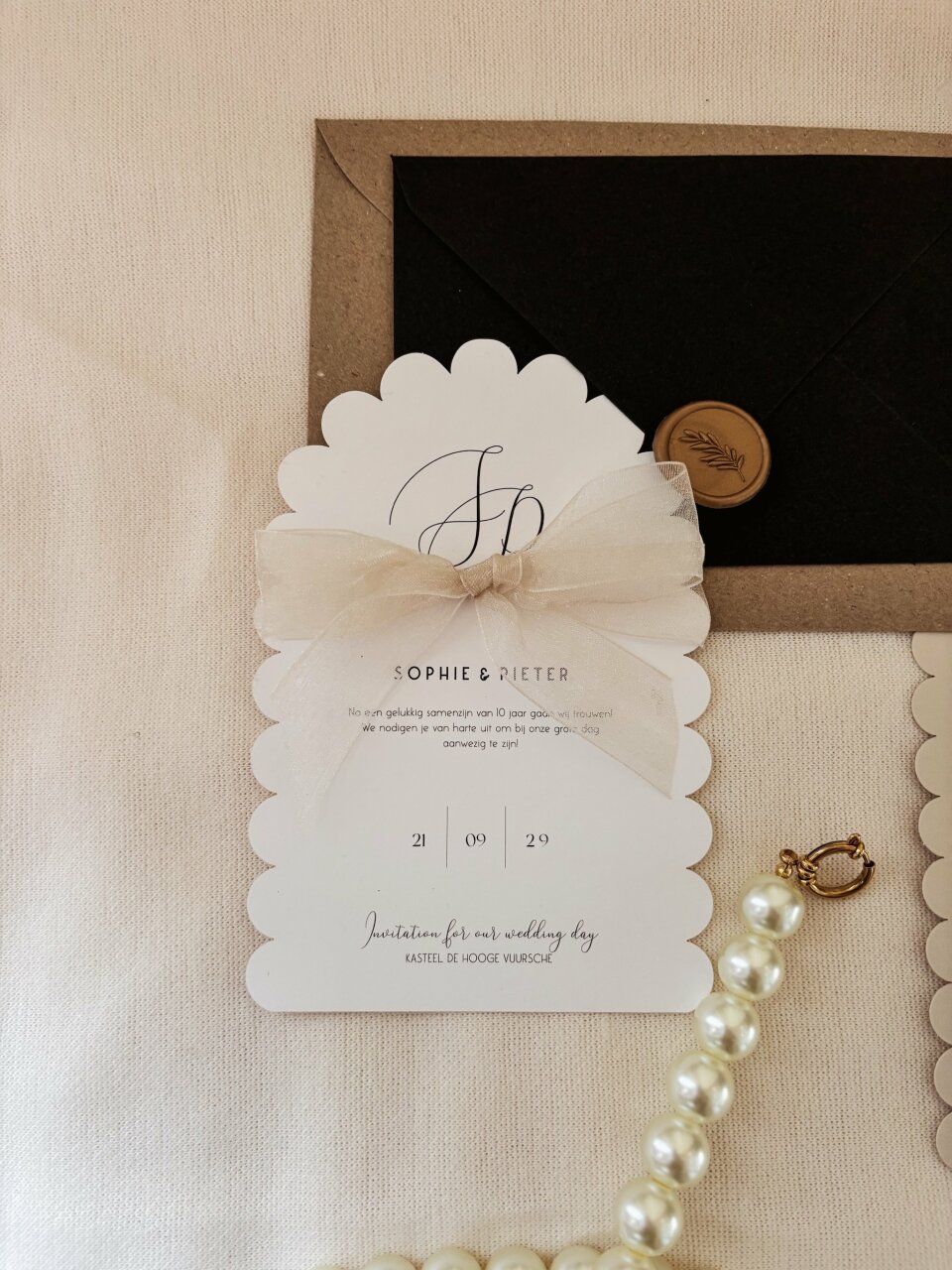 een afbeelding van een huwelijksuitnodiging met parels erop