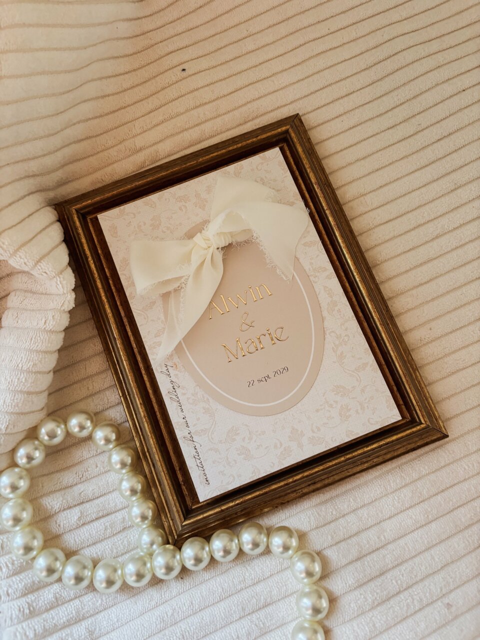 een afbeelding van een fotolijst en parels op een bed