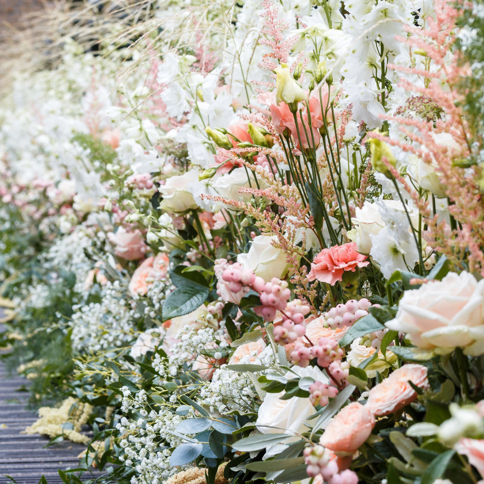 een lange rij bloemen op een houten looppad