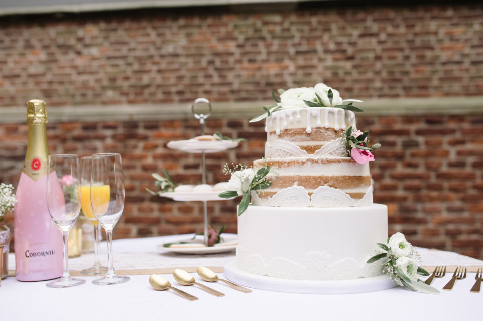 een bruidstaart op een tafel met champagne en bloemen