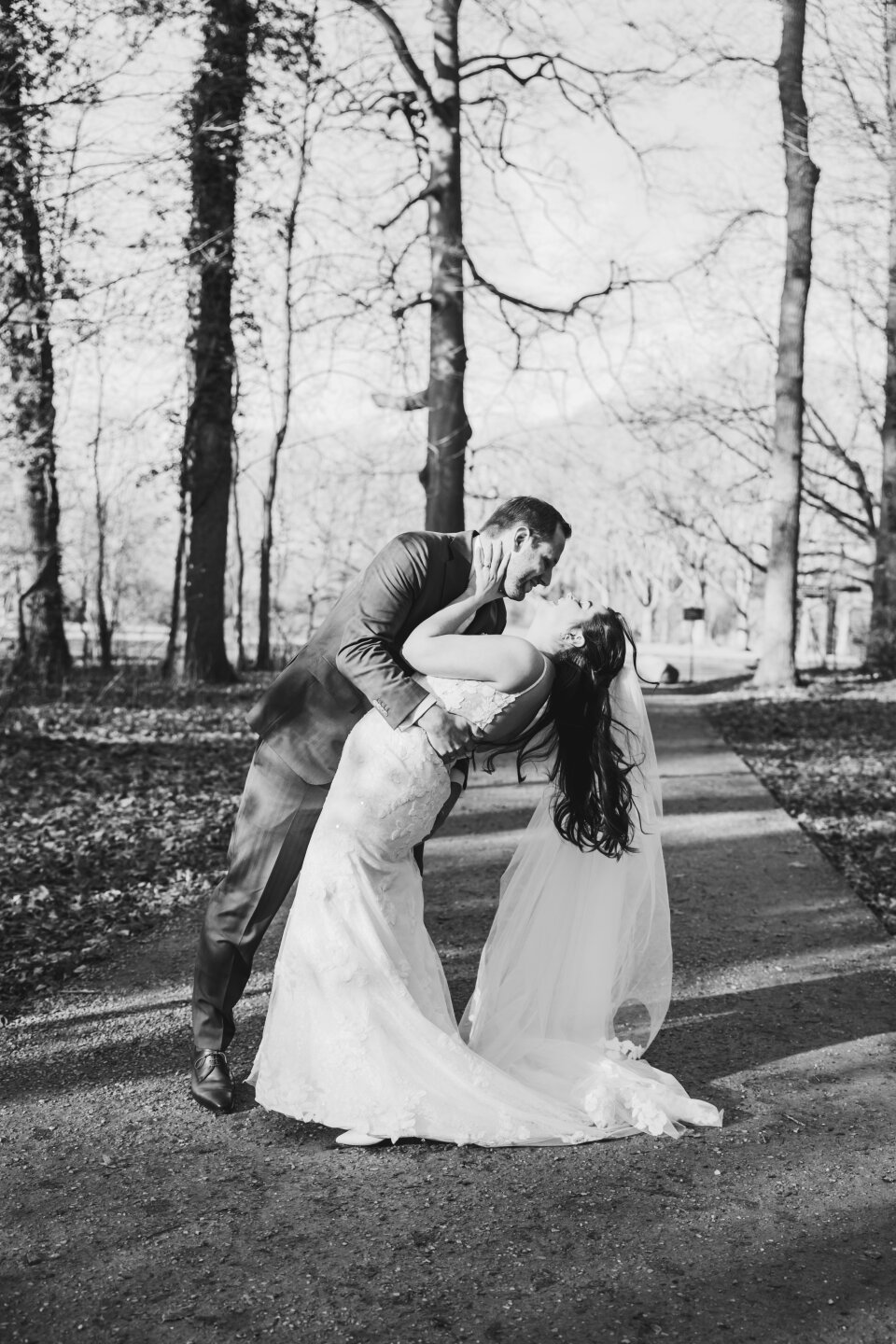 het bruidspaar dat kust op deze zwart-wit foto