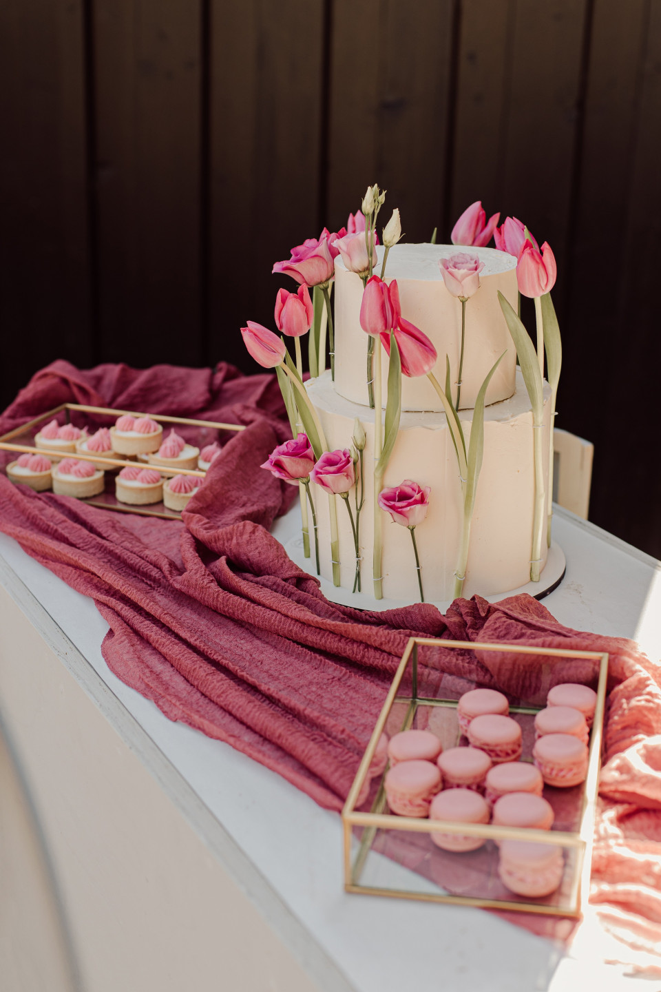 een tafel met een taart, cupcakes en koekjes erop